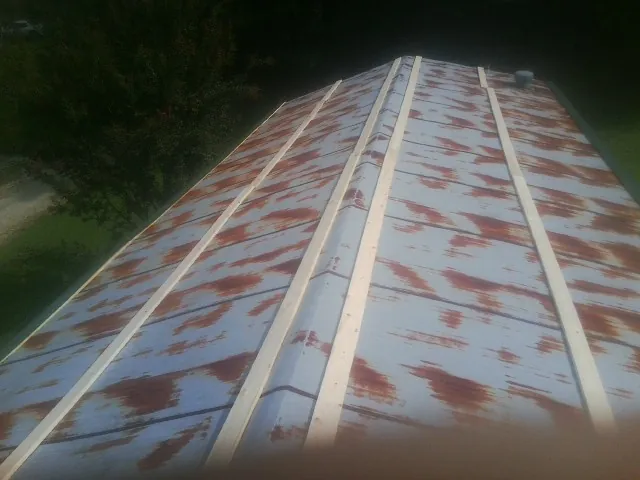 Rusted metal roof panels with new wood purlins before replacement — Storm Damage Roof Repair in Sangerfield by Roofing Brothers