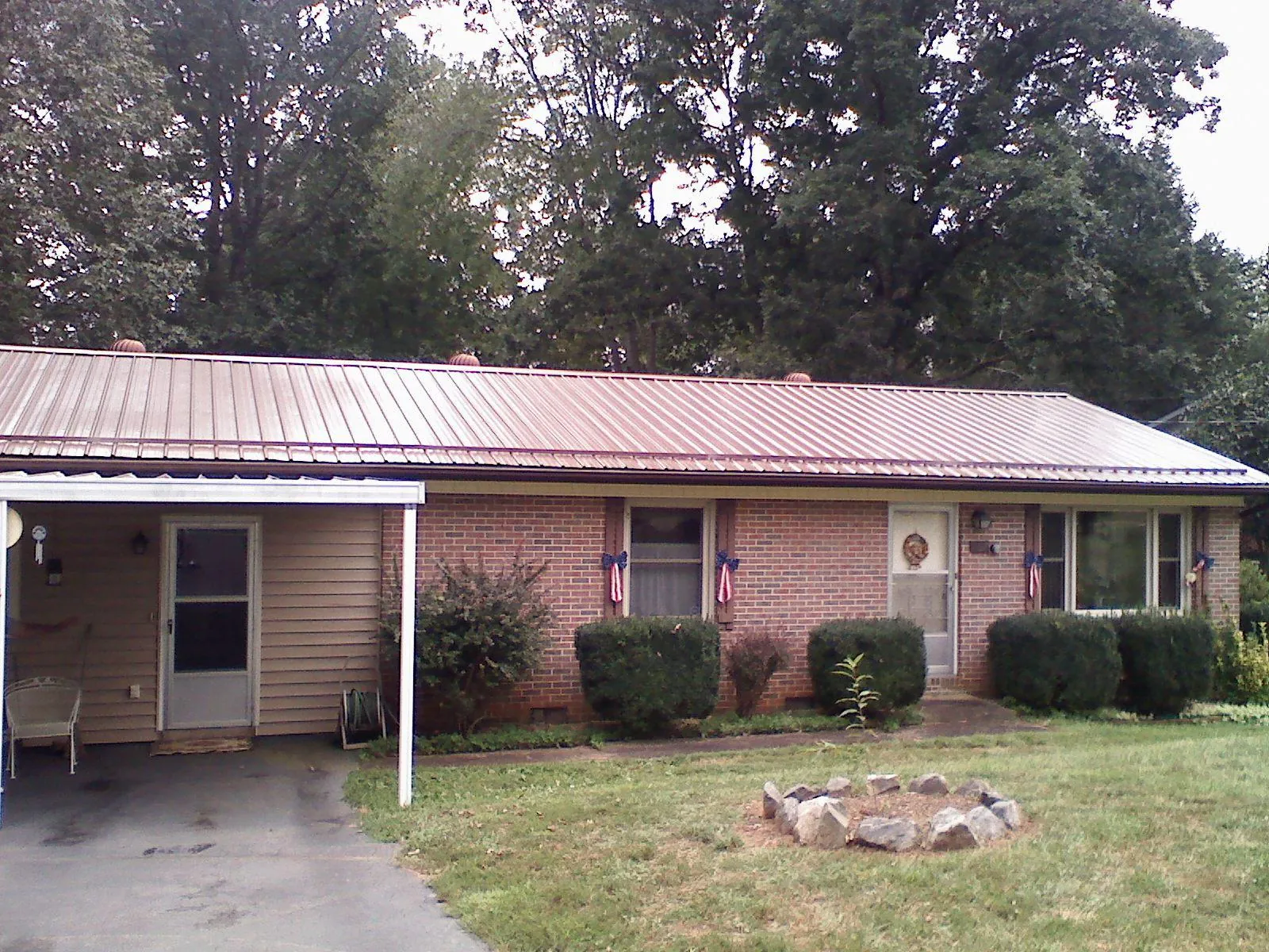 Bronze metal roof and carport on a brick ranch home — Roof Repair work by our crew in Sangerfield
